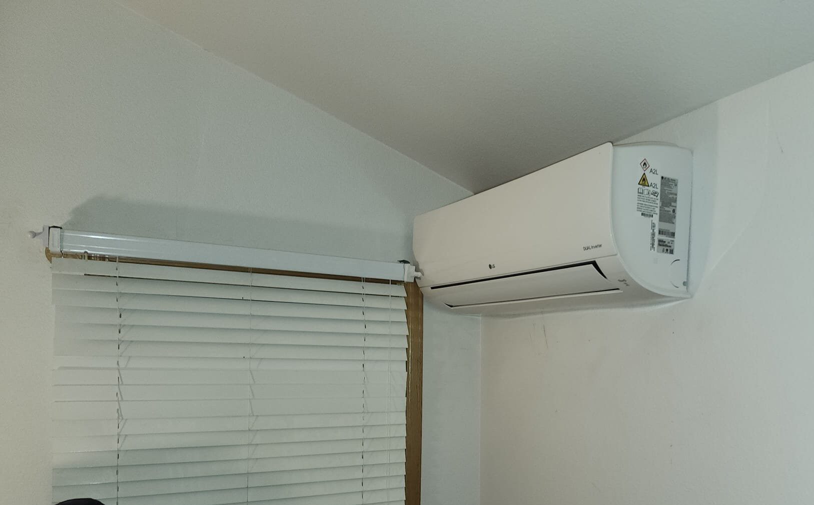 LG ductless mini-split indoor head installed high on wall in a bedroom
