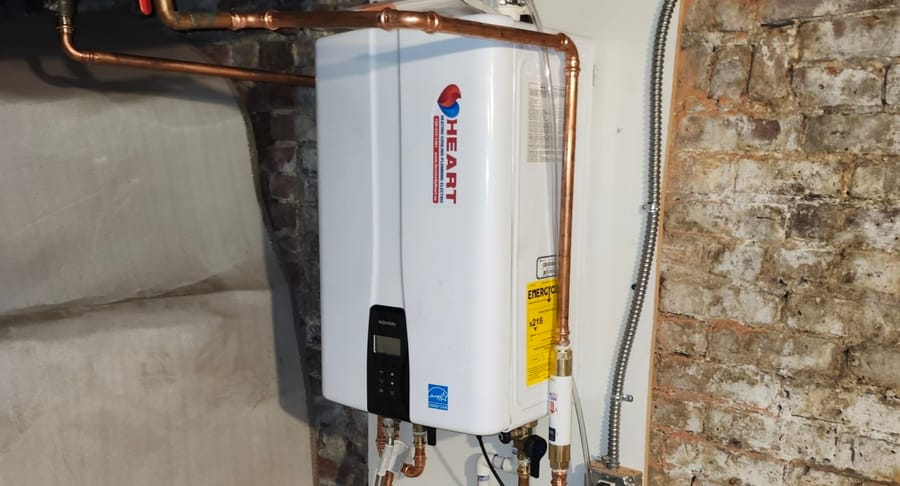 Tankless water heater unit in basement.