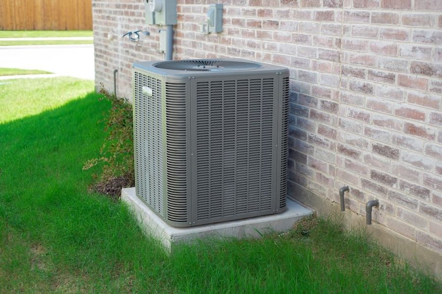 Outdoor air conditioning system on a concrete slab surrounded by grass.